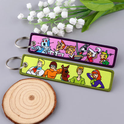 Embroidered Keychain - Cartoon Characters Scooby-Doo gang, retro robots, Humorous stick figures, and action-packed dinosaurs and warriors.
